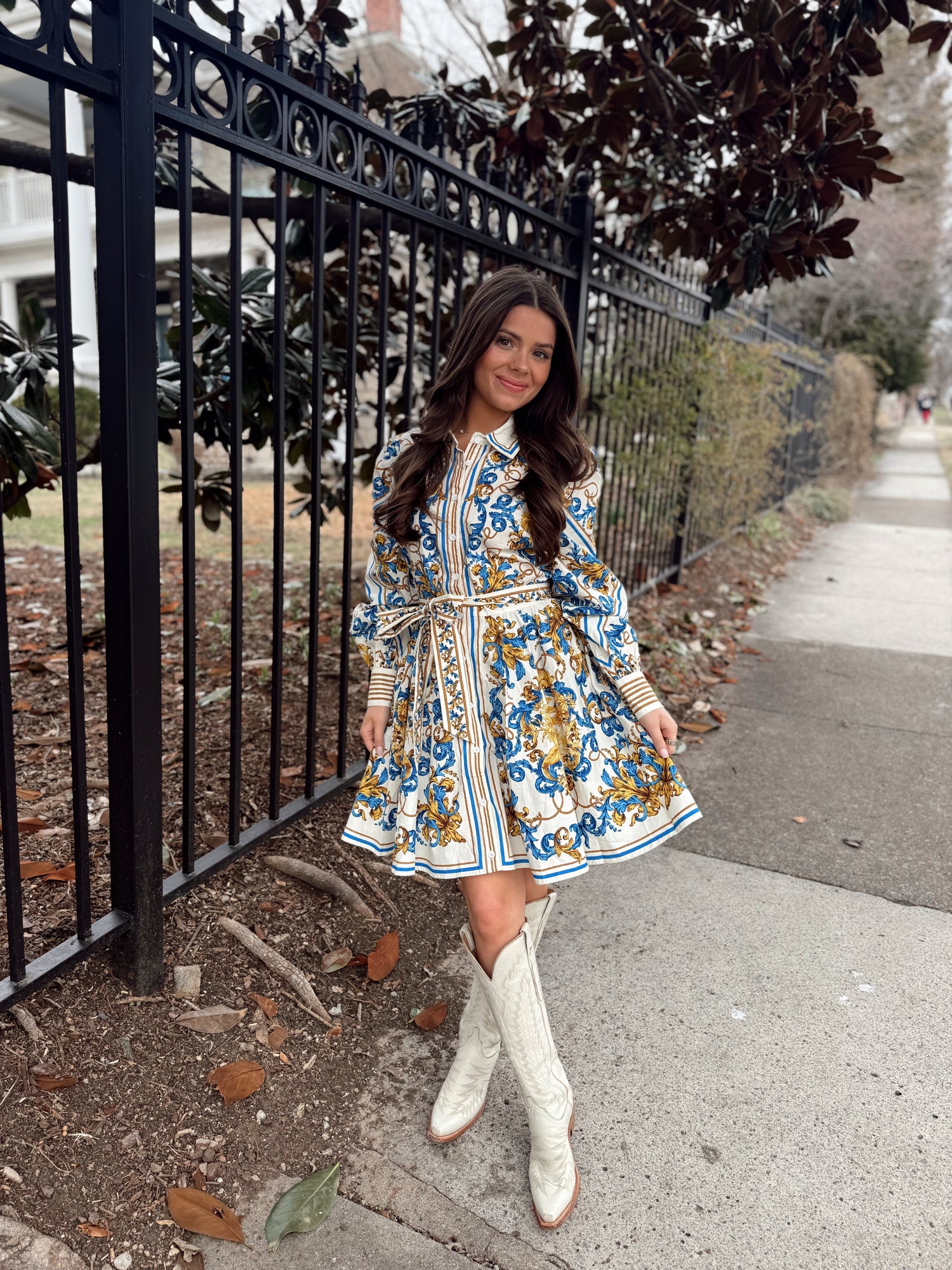 Blue and gold baroque print mini dress with long sleeves, button-front detail, and matching waist tie.